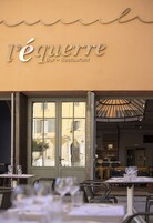 Un restaurante con terraza y un letrero que dice "l'équerre Bar - Restaurant".
