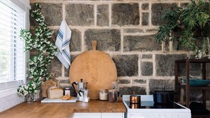 A kitchen with a stone wall, wooden counter, and various kitchen items. - ELLERSLIE COTTAGE - FOR LOVERS AND DREAMERS (Glenhope)