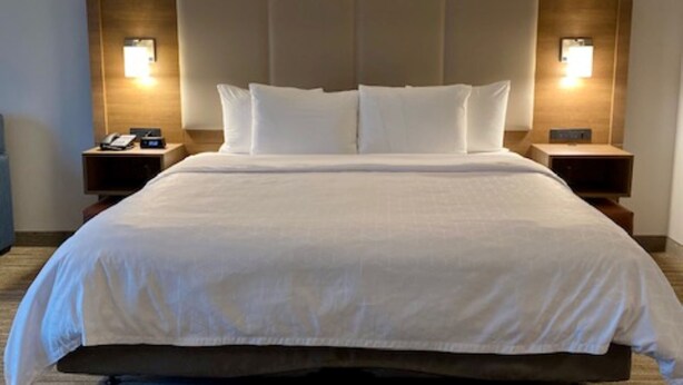 A hotel room with a large bed, two bedside tables, and wall-mounted lamps. - Holiday Inn Express & Suites The Dalles by IHG (The Dalles)