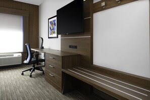 A modern office space with a desk, chair, and built-in TV.