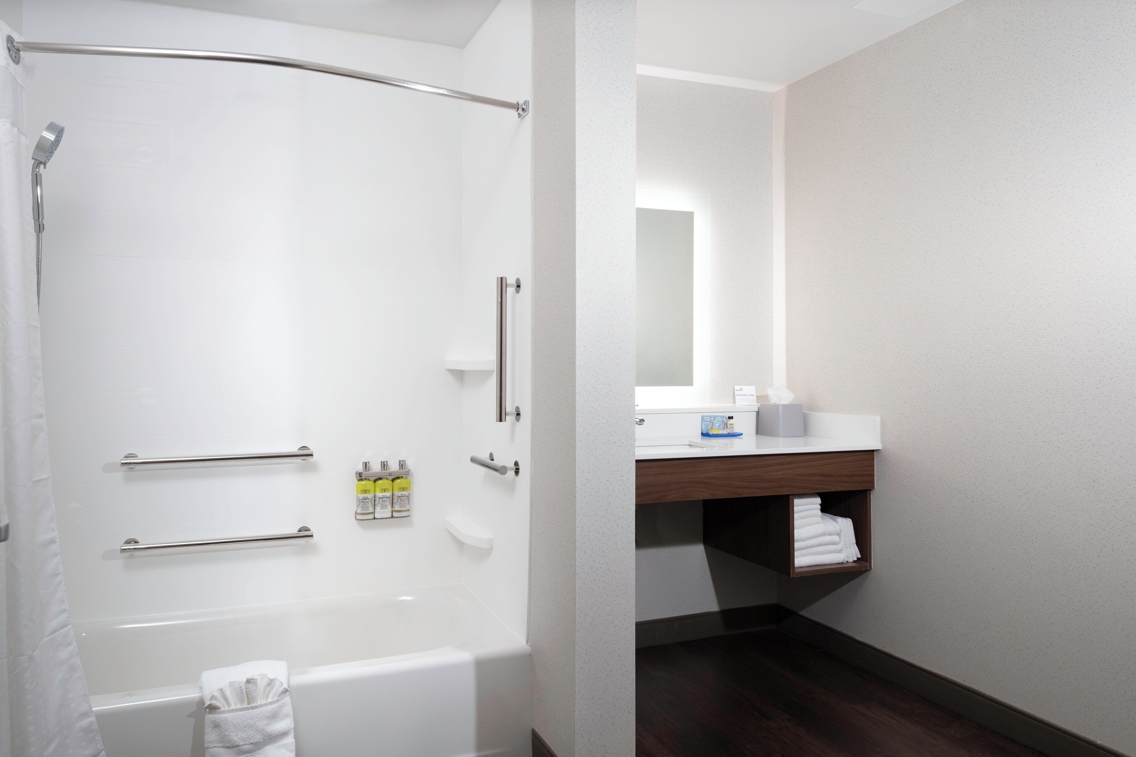 Ein modernes Badezimmer mit einer begehbaren Dusche, einer Toilette und einem Waschtisch mit Spiegel.