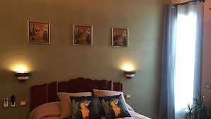 A bedroom with a large bed, a wooden headboard, and three wall-mounted lamps. - Signorino Suites&Pool (Marsala)