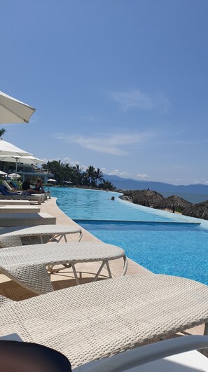 Relax by the pool surrounded by palm trees and ocean views.