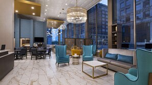 A modern lobby with seating, a reception desk, and large windows offering city views. - Hyatt Place Tulsa Downtown (Tulsa)