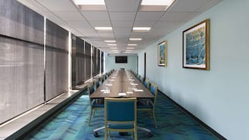A conference room with a long table, chairs, and a large window.
