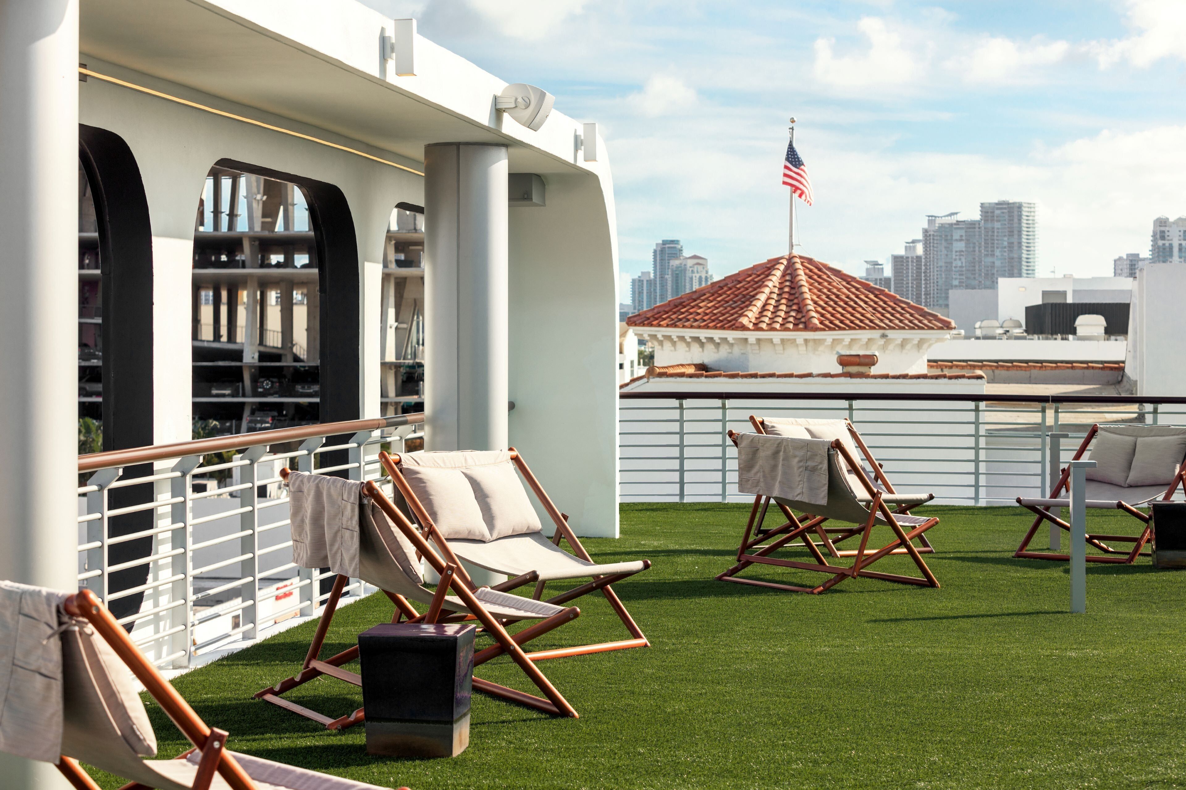 A rooftop terrace with outdoor seating and a city skyline view.