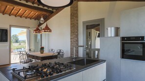 A modern kitchen with a gas stove, stainless steel appliances, and pendant lighting.