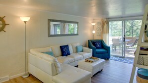 A living room with a white sofa, a blue armchair, and a floor lamp. - Updated Home w/ Deck: 2 Mi to Sister Bay Beach! (Sister Bay)