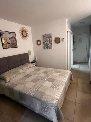 Un dormitorio con una cama grande, una mesita de noche y decoración en la pared.