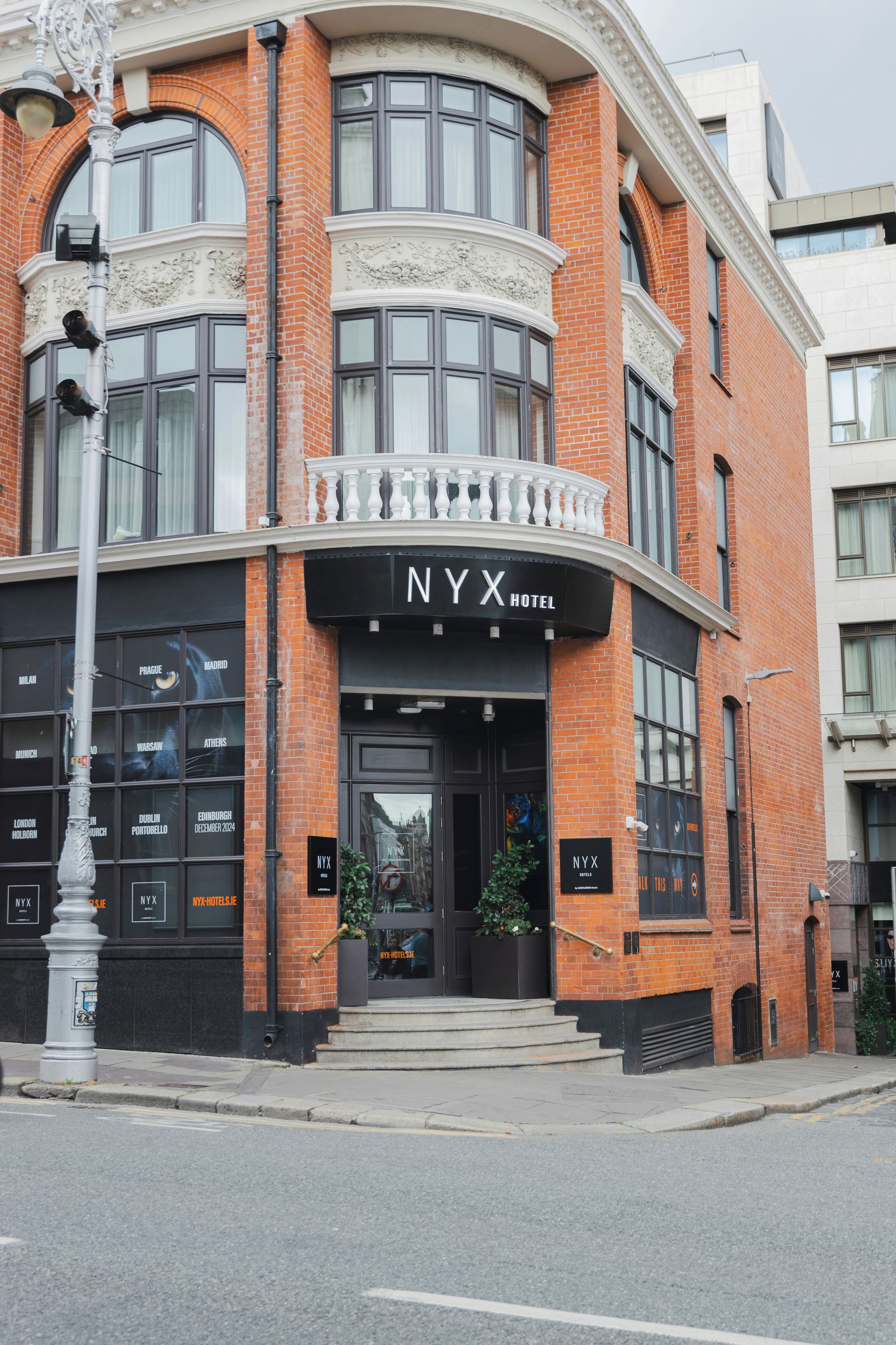 A NYX Hotel with a black facade, large windows, and a black entrance.