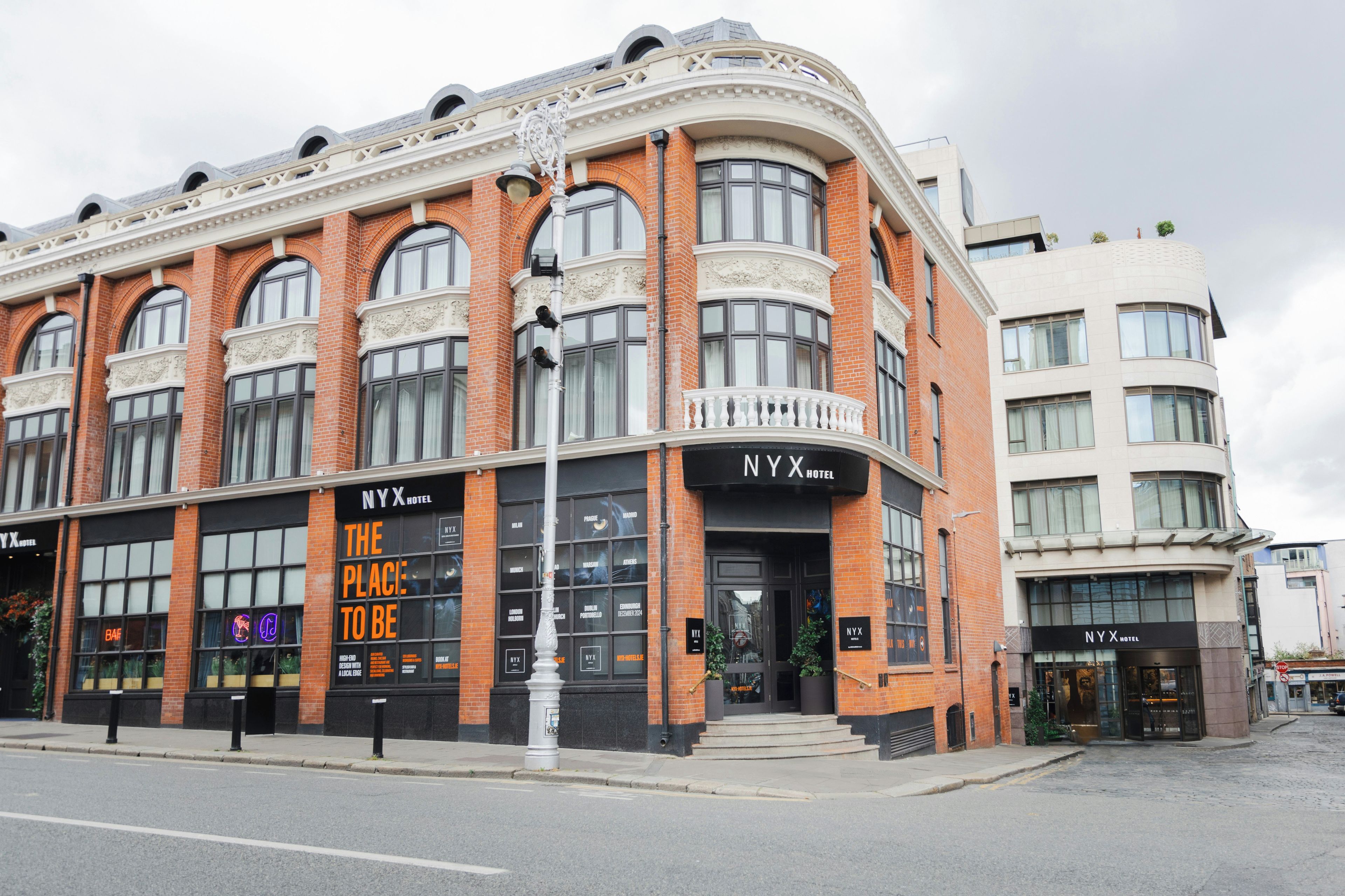 A hotel with a curved facade, large windows, and a prominent entrance.