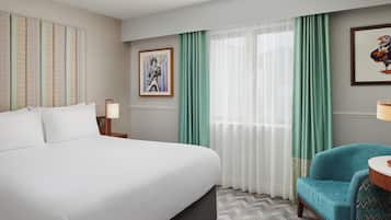 Une chambre d’hôtel avec un grand lit, une chaise, un bureau et une fenêtre avec des rideaux.