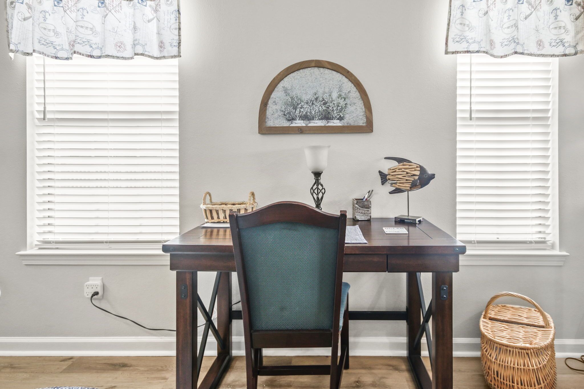Un comedor con una mesa de madera, una silla, una lámpara de pared y una escultura decorativa de un pez.