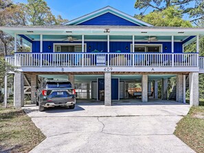 A two-story building with a blue exterior and a covered front porch. - Heated Pool Access | 5*Clean | Flex Cancelation (Tybee Island)