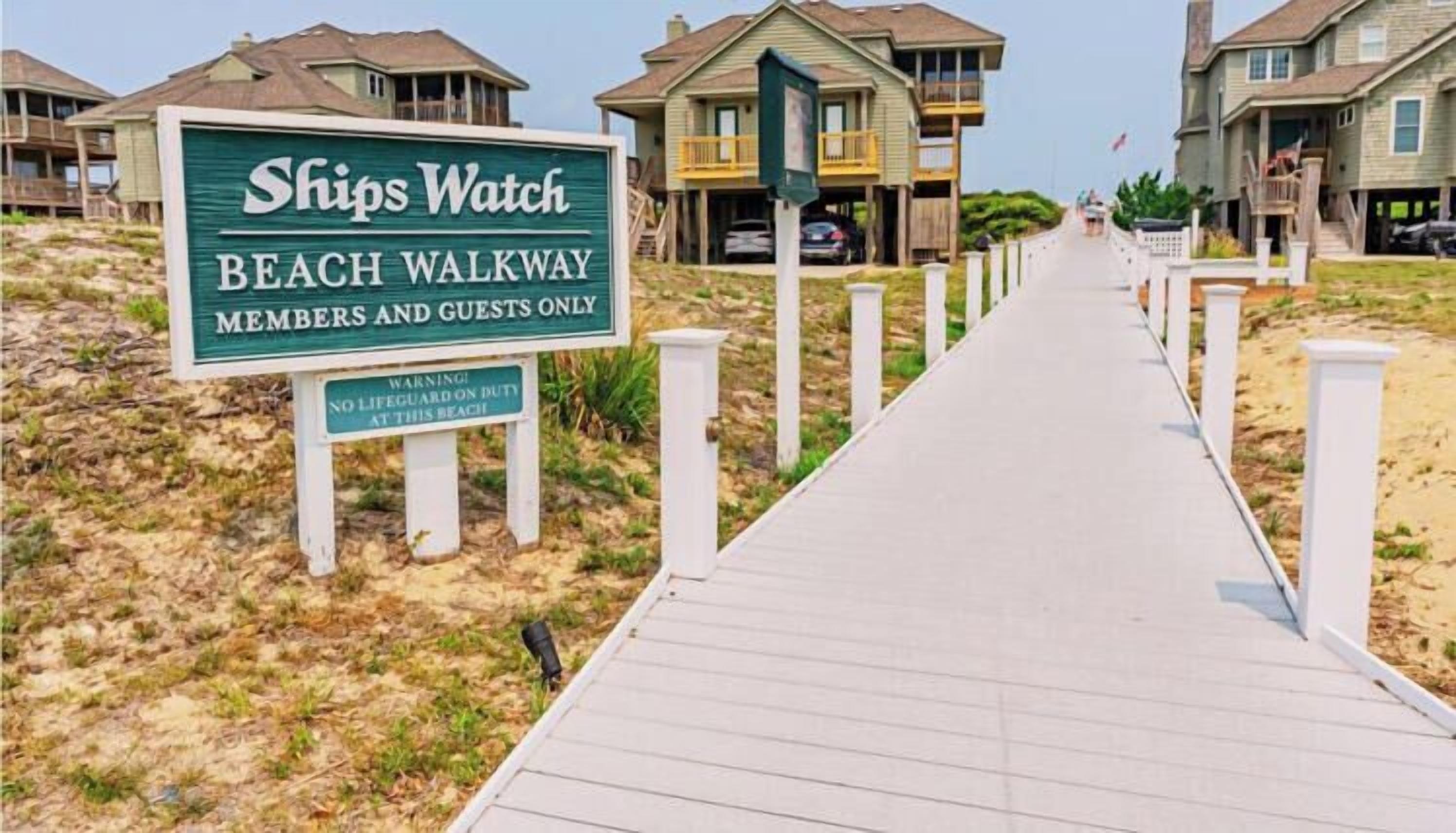 A beach walkway sign for Ships Watch with a warning about no lifeguard on duty.