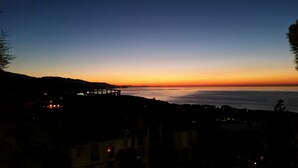 Una vista del atardecer costero con un muelle que se adentra en el agua.
