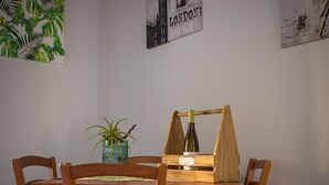 Un comedor con una mesa y sillas de madera, un florero con una planta y dos carteles en la pared.