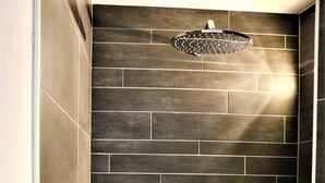 A shower with a handheld showerhead and a wall-mounted rain showerhead. - Apartment Weisse Zinne (St.Johann)