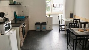 A modern kitchen with a microwave, coffee maker, and a small dining area with a table and chairs.
