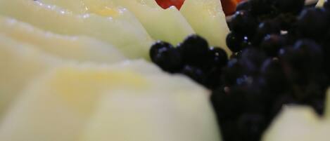 A close-up of a fruit platter with various fruits including watermelon, apples, and berries.