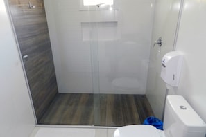 Bathroom features a glass-enclosed shower area and a minimalist design with clean lines.