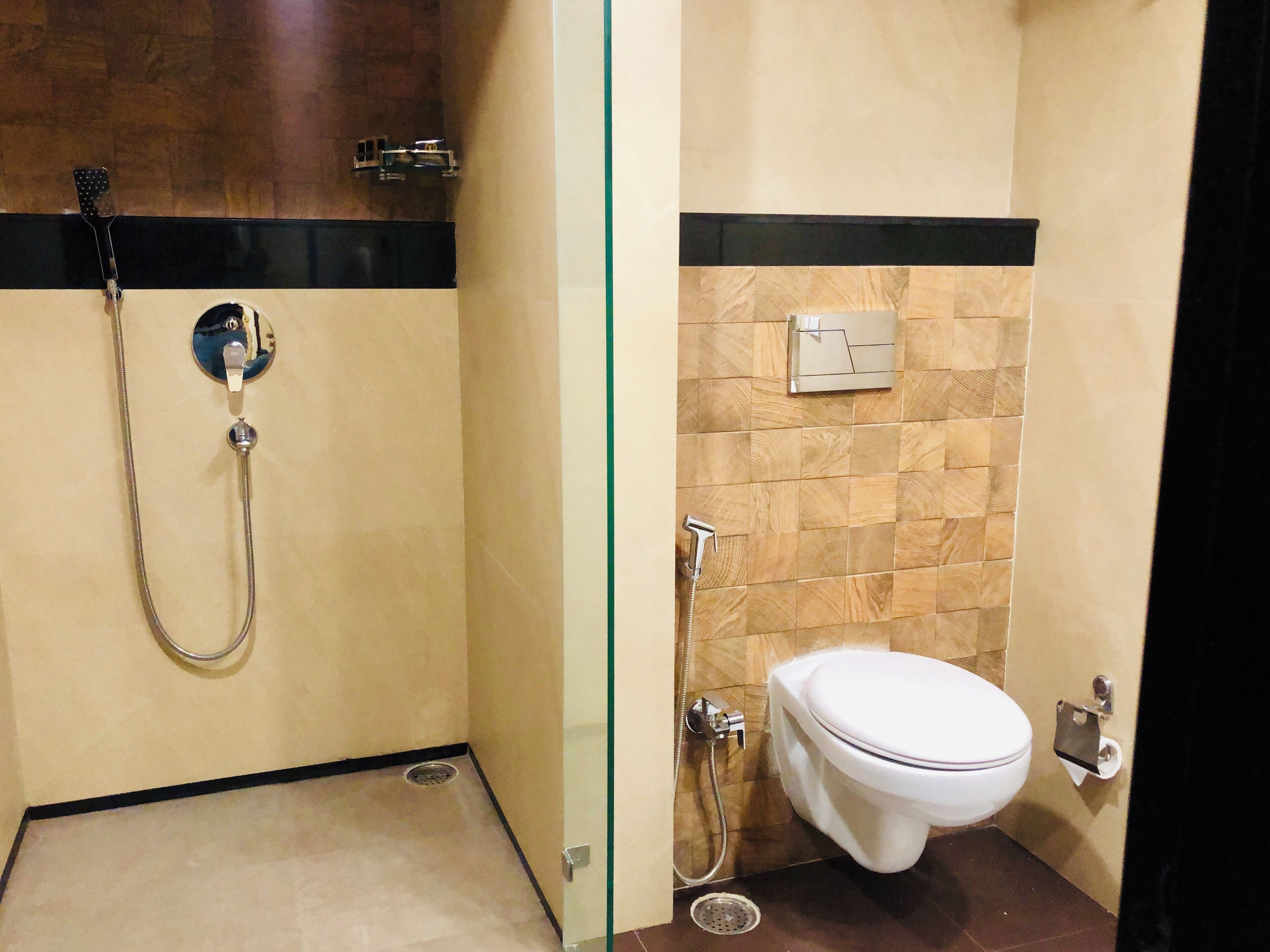 Un baño con ducha, inodoro y un lavamanos pequeño.