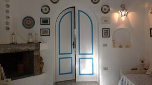 Una stanza con camino, un letto e una porta con dettagli blu.