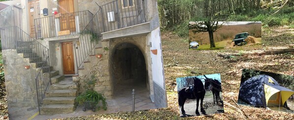 A rustic stone building with a wooden door and steps leading to a balcony. - San Procopio (Troina)