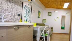 Una cocina moderna con un mueble de madera, un lavamanos y una zona de comedor con mesa y sillas.
