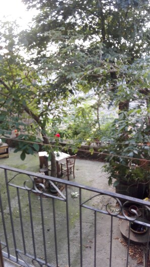 A garden area with a table and chairs, surrounded by greenery and a metal fence. - San Procopio (Troina)
