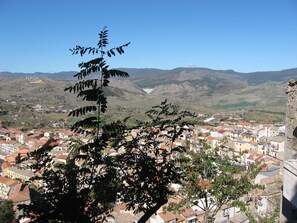 A town with red-roofed buildings, a valley, and mountains in the background. - San Procopio (Troina)