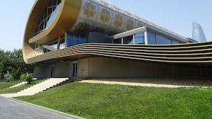 A modern building with a unique curved facade and a large circular window. - Yeshim Guest House (Baku)