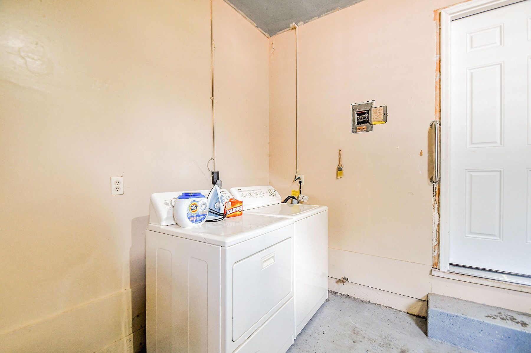 A laundry area with a washing machine, a dryer, and a wall-mounted iron.