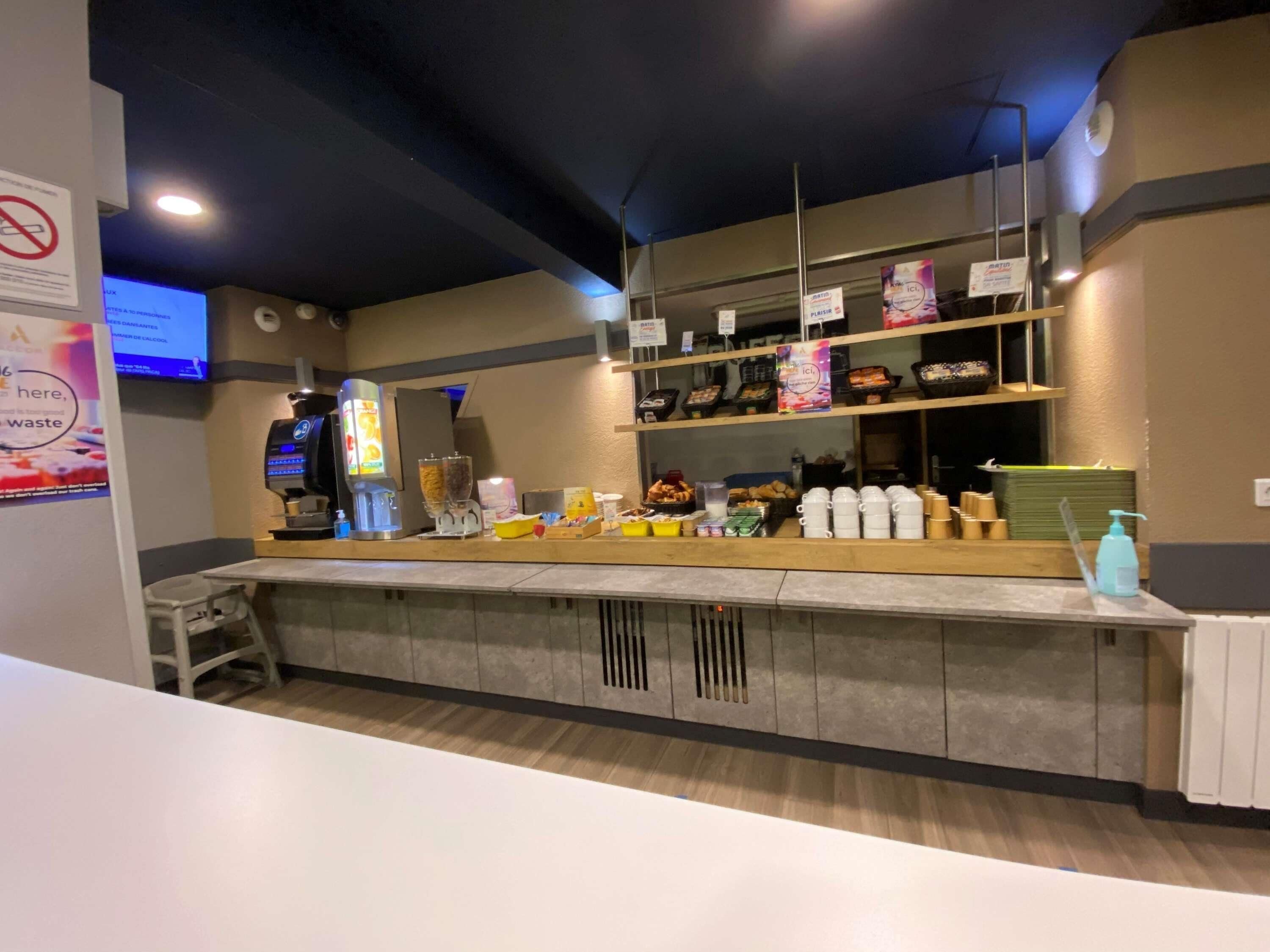 A self-service breakfast bar with a coffee machine, cereal dispensers, and various food items.