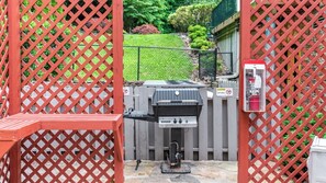 Una parrilla para barbacoa con panel de control, un cartel de prohibido fumar y una señal de precaución por la parrilla caliente.