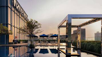 Una piscina al aire libre, sombrillas, tumbonas