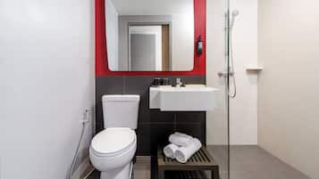 A modern bathroom with a toilet, sink, and shower.