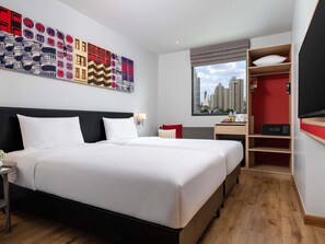 Une chambre d’hôtel avec un grand lit, un bureau, une armoire et une vue sur la ville.