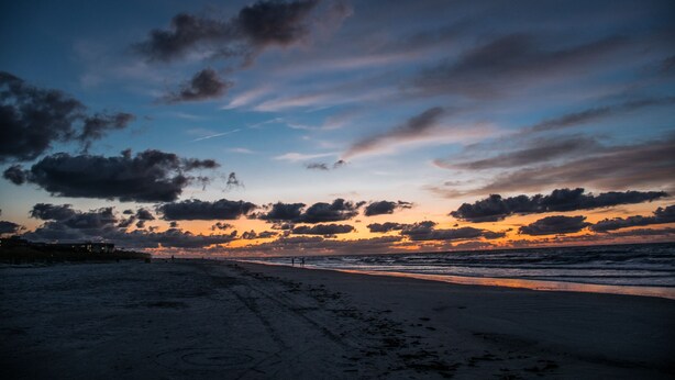 A beach with a sunset, clouds, and a distant shoreline. - Players Club - 2 Bedroom (Hilton Head Island)