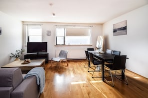 Relax in this open-plan living space with a dining table, comfortable sofa, and flat-screen TV.