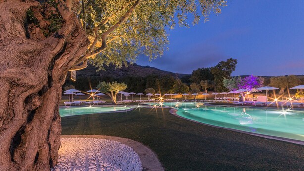 A pool area with multiple water features, surrounded by trees and umbrellas. - Tenuta Re Ferdinando (Santa Maria Capua Vetere)