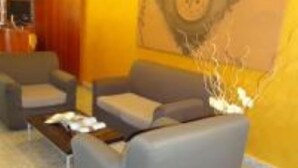 A lobby with a sofa, armchairs, and a coffee table. - Tea Palace Hotel (Casapulla)
