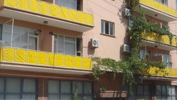 A multi-story building with balconies covered in yellow fabric.