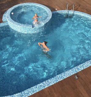 A swimming pool with a mosaic tile edge, a hot tub, and a wooden deck area. - Superbly Equipped, Spectacular Views, Infinity Pool and Jacuzzi (Dobrota)