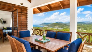 A wooden table with blue cushioned chairs, a bottle, and a glass on a tablecloth. - Hilltop Villa with great views out to sea - Villa Cadasse (Cap Estate)
