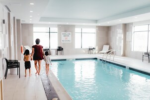 Una piscina interior con un letrero que indica agua poco profunda y prohibido bucear.