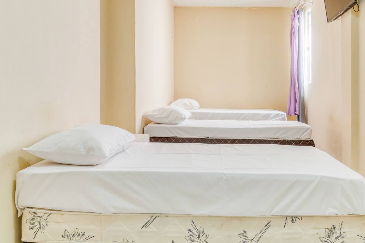 Un lit simple avec une literie blanche et une housse de lit à motifs floraux.