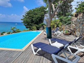 A wooden deck with a pool, lounge chairs, and a view of the ocean. - Villa Pineapple - Grand Case (Hotel Esplanade Area) 5 min Orient Bay (Grand-Case)