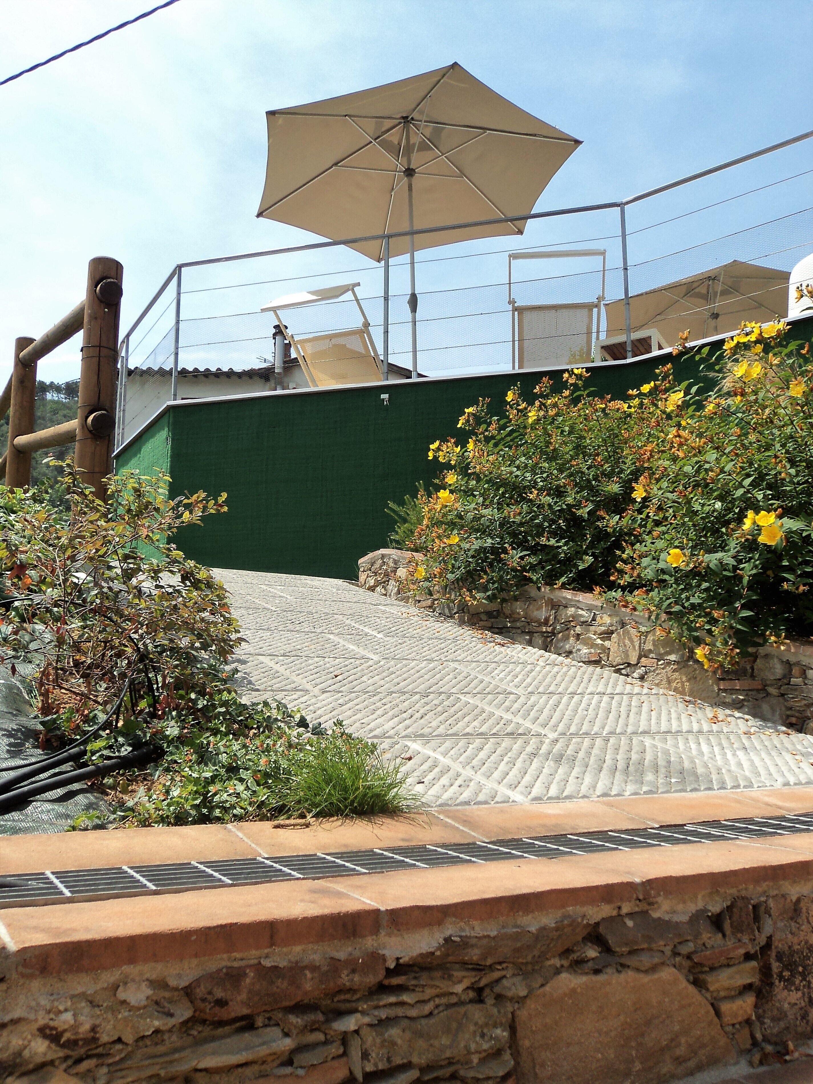 Una terraza en la azotea con pérgola, mobiliario exterior y vistas al mar.