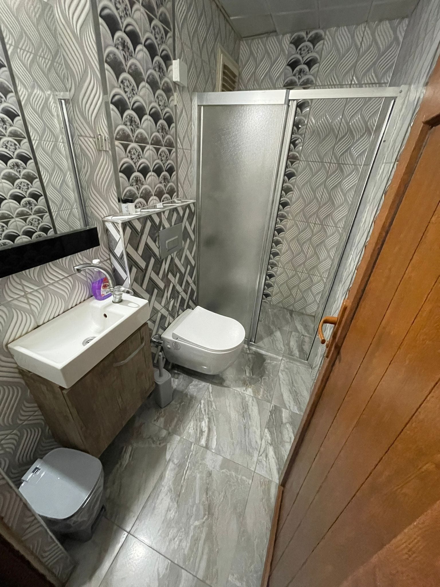 A bathroom with a sink, toilet, and shower area.
